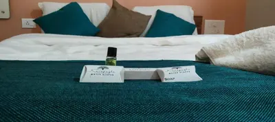 a bottle of wine on top of a bed at Karapuzha Water Scapes Wayanad in Wayanad