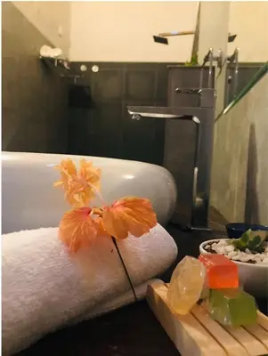 a bathroom with a sink and a towel with flowers on it at Coorg Happy Estate Stay in Madikeri