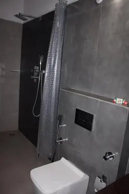 a bathroom with a shower and a toilet in it at Coorg Happy Estate Stay in Madikeri