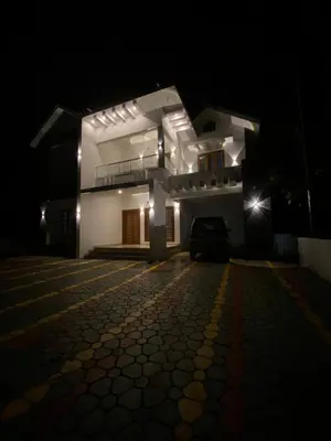 a white house at night with a driveway at HOLLYWOOD Villa in Sultan Bathery