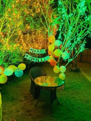 a table with a sign that says happy birthday and a tree with lights at CHERAI LAKE RESORT in Cherai Beach