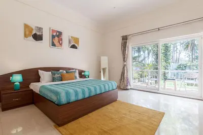 a bedroom with a bed and a large window at Bask In The Greens Coorg with Private Pool - Pet Friendly - Complimentary Breakfast in Madikeri