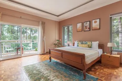 a bedroom with a large bed and windows at Bask In The Greens Coorg with Private Pool - Pet Friendly - Complimentary Breakfast in Madikeri