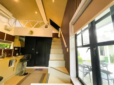 a tiny house with a staircase and a kitchen at The Little Acres Cherai in Vypīn