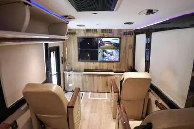 a room with chairs and a tv in a train at FRONTLINES CARAVAN in Kadikkād