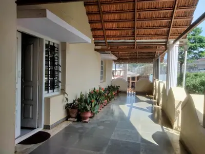 a hallway of a building with potted plants at Prashanth Family Homestay in Madikeri