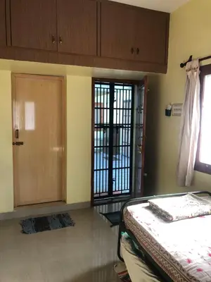 a room with a bed and a door and a window at Single room Homestay Second floor in Palani