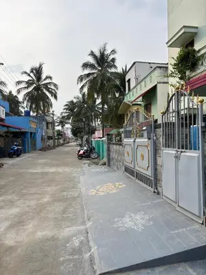 an empty street with palm trees and a fence at Single room Homestay Second floor in Palani