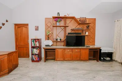 a living room with a desk with a tv at Alite Posh 4 BHK Villa in Thrissur Town in Trichūr