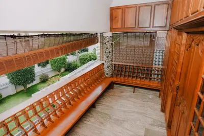 an empty room with benches and a balcony with plants at Alite Posh 4 BHK Villa in Thrissur Town in Trichūr