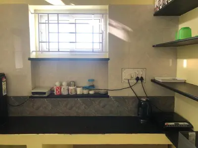 a kitchen with a window and a counter in a room at Aishwarya Nivas in Palani