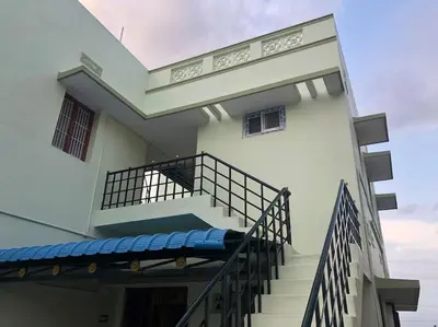 a building with stairs and a balcony with a porch at Aishwarya Nivas in Palani