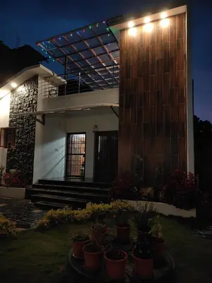 a house with lights on the side of it at Kodai Diva Inn - Home Stay in Kodaikānāl