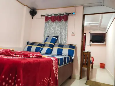 a bedroom with a bed with blue and white pillows at AKS Home Stay in Munnar
