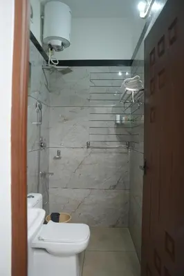 a bathroom with a shower with a toilet and a sink at AVANTI CASTELLO in Guruvāyūr