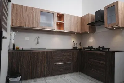 a kitchen with wooden cabinets and a sink at AVANTI CASTELLO in Guruvāyūr
