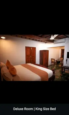 a bedroom with two beds and a living room at Kalappura Farm House Heritage in Ottappālam