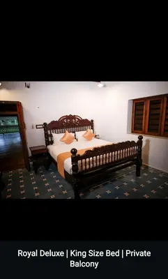 a bedroom with a wooden bed with pillows on it at Kalappura Farm House Heritage in Ottappālam