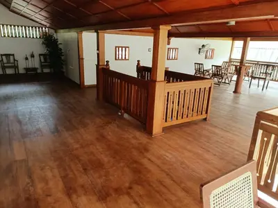 a large room with a wooden floor and tables and chairs at Kalappura Farm House Heritage in Ottappālam
