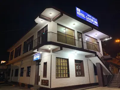 a building with a sign on top of it at night at Hotel Caveri Inn in Madikeri