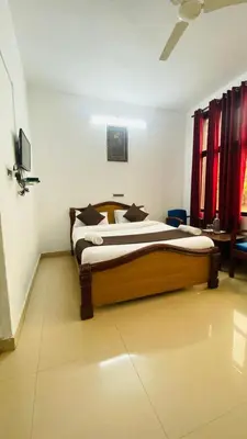 a bedroom with a large bed in a room at Hotel Caveri Inn in Madikeri