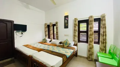 a bedroom with two beds and a window at Hotel Caveri Inn in Madikeri