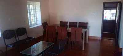 a room with a table and chairs and a window at Mercara Aloft in Madikeri
