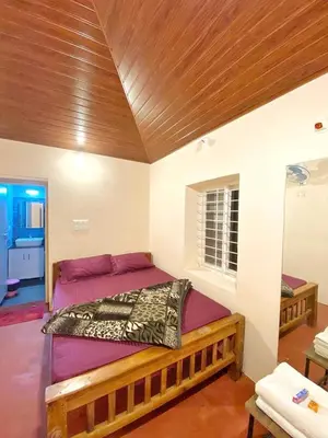 a bed in a room with a wooden ceiling at Mercara Aloft in Madikeri