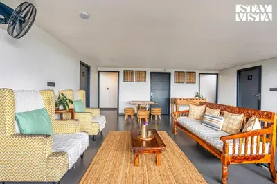 a living room with couches and a table at StayVista at Griha Sankalpa with Mountain View, BBQ Wayanad in Koroth