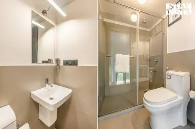 two images of a bathroom with a toilet and a sink at StayVista at Griha Sankalpa with Mountain View, BBQ Wayanad in Koroth