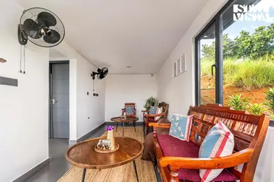 a living room with a table and chairs and a window at StayVista at Griha Sankalpa with Mountain View, BBQ Wayanad in Koroth