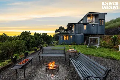 a house with benches and a fire pit at StayVista at Griha Sankalpa with Mountain View, BBQ Wayanad in Koroth