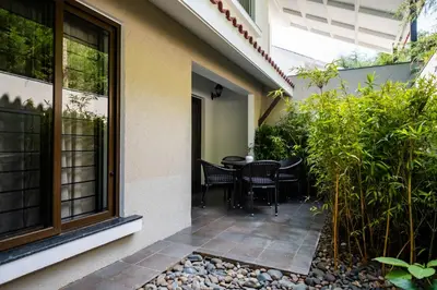 a patio with a table and chairs next to a building at Dvara Luxury Resort Kodaikanal in Kodaikānāl
