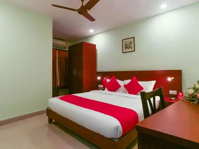a bedroom with a large bed with red pillows at HOTEL NEWCASTLE in Vadakkāncheri