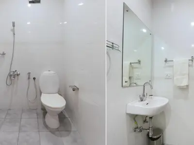 a white bathroom with a toilet and a sink at HOTEL NEWCASTLE in Vadakkāncheri