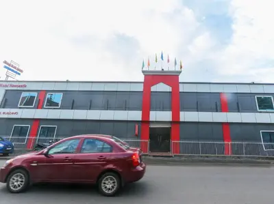 a red car parked in front of a building at HOTEL NEWCASTLE in Vadakkāncheri