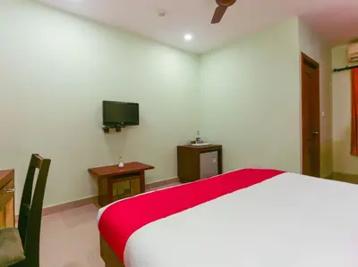 a bedroom with a bed and a tv on the wall at HOTEL NEWCASTLE in Vadakkāncheri