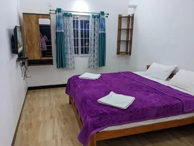 a bedroom with a purple bed with towels on it at DIAMOND HILL VIEW in Ketti
