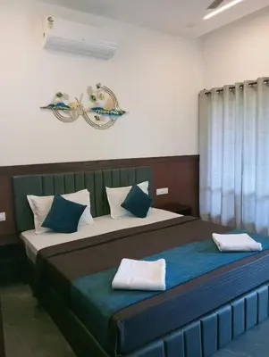 a bedroom with a large bed with blue and white pillows at Teaside Inns in Vythiri