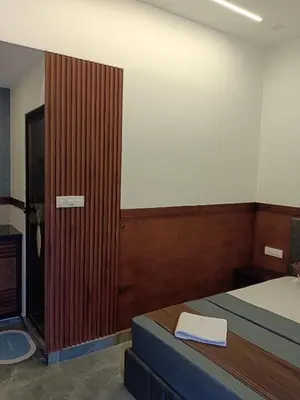 a bedroom with a bed and a wooden door at Teaside Inns in Vythiri