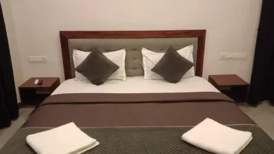 a bedroom with a large bed with pillows at Teaside Inns in Vythiri