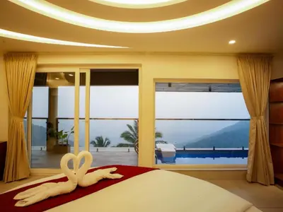 a bedroom with a bed with a large window at Mount Stratus Resort Vayalada in Bālūssheri