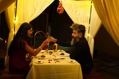 a man and a woman sitting at a table at Mount Stratus Resort Vayalada in Bālūssheri