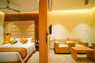 a hotel room with a bed and a couch and chairs at Hotel Nakshathra- A Royal Stay in Palani