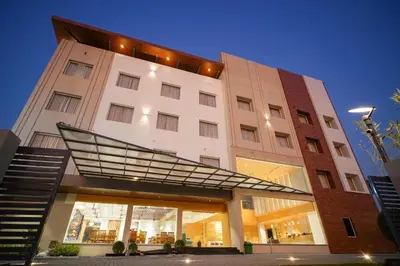 a large white building with a staircase in front of it at Hotel Nakshathra- A Royal Stay in Palani