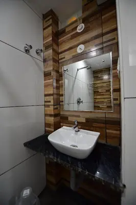 a bathroom with a sink and a mirror at Hotel Surya Lodge in Mysore
