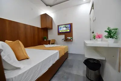 a small bedroom with a bed and a sink at Hotel Surya Lodge in Mysore