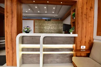 a room with a partition with a couch and a tv at Hotel Surya Lodge in Mysore