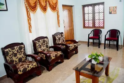 a living room with chairs and a coffee table at Holidayincoorg Royal Mansion in Madikeri