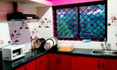 a kitchen with red cabinets and a window and a sink at Holidayincoorg Royal Mansion in Madikeri